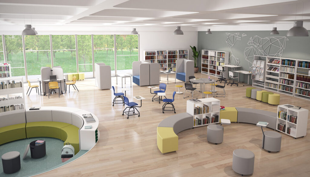 Una biblioteca moderna con asientos curvos, mesas redondas, sillas de colores y estanterías Mobiliario Escolar. Grandes ventanales con vistas a la vegetación en este espacio diáfano y luminoso, con murales geométricos y varias zonas de estudio.